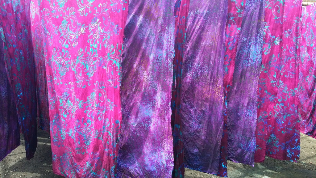 All the fabric is dyed many times to add the varied colors that make our prints so beautiful. All the dyes rely on the sun to set the colors. Here the fabrics hang to dry outside. The colors are even more beautiful outside in the sunlight.